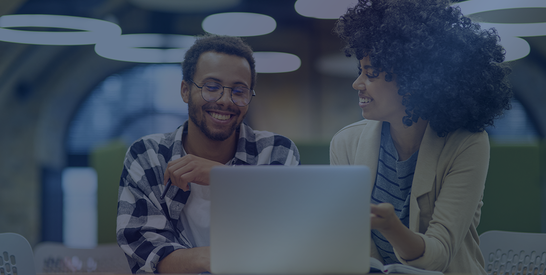Um homem e uma mulher sentados na frente de um computador